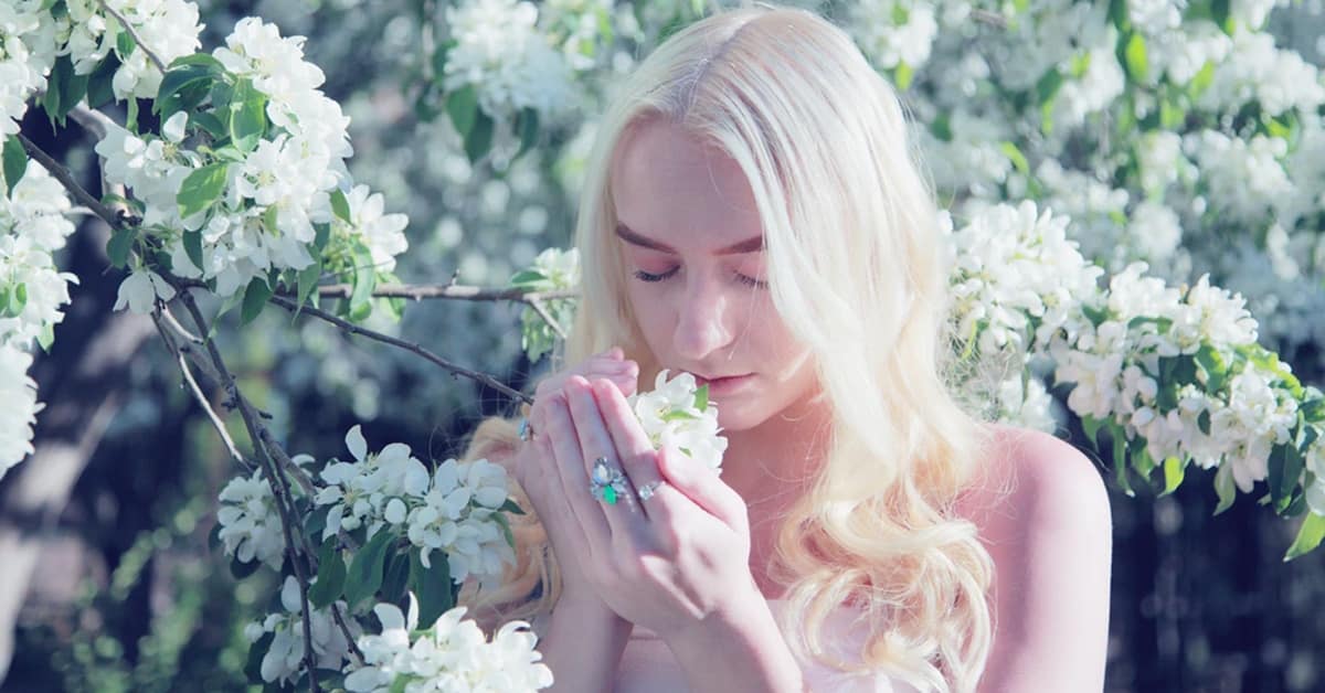 Ethereal woman smelling flowers